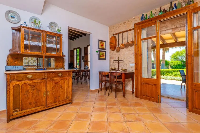 Un comedor rústico con muebles de madera y una mesa junto a una puerta abierta.