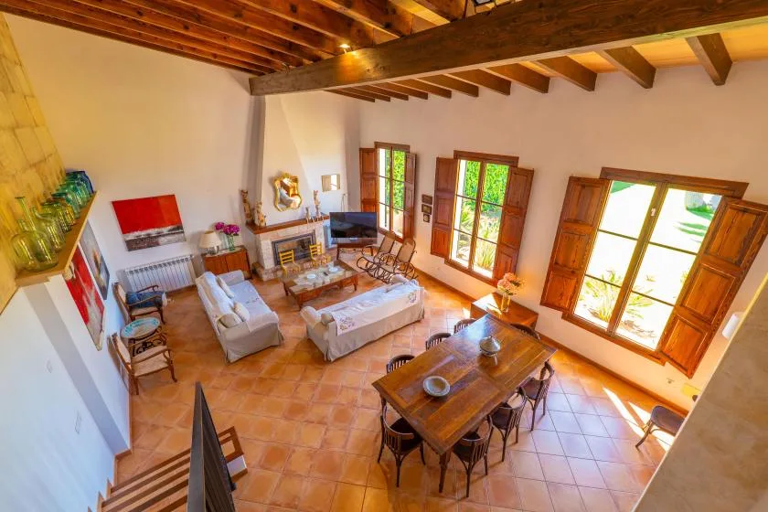 Una sala luminosa con mesa de comedor, asientos y ventanas grandes.