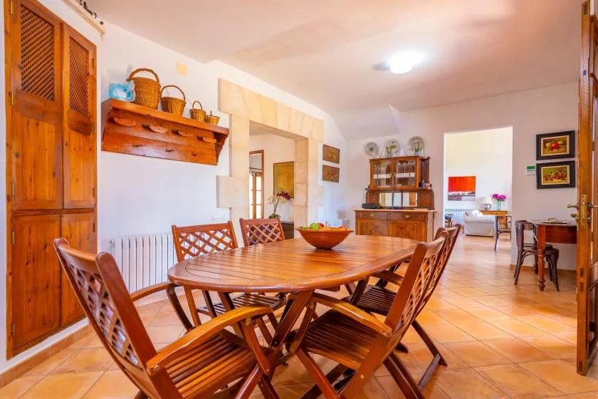Comedor con una mesa y sillas de madera junto a una puerta abierta.