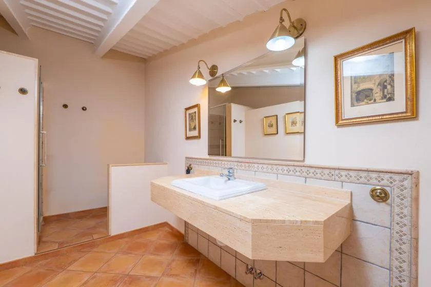 Un lavabo de baño con espejo y luces instaladas en la pared.