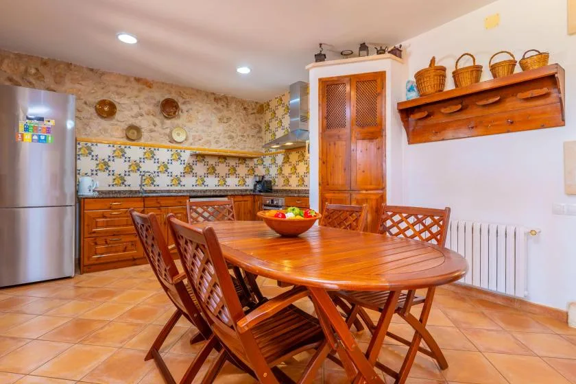 Una cocina rústica con comedor, mesa de madera y sillas.