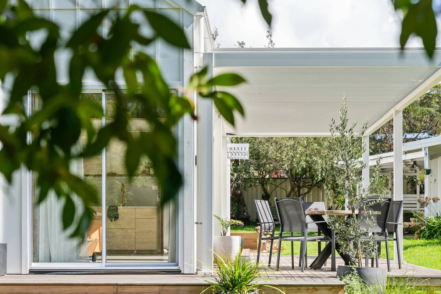 A covered outdoor dining area beside a glass-walled building.