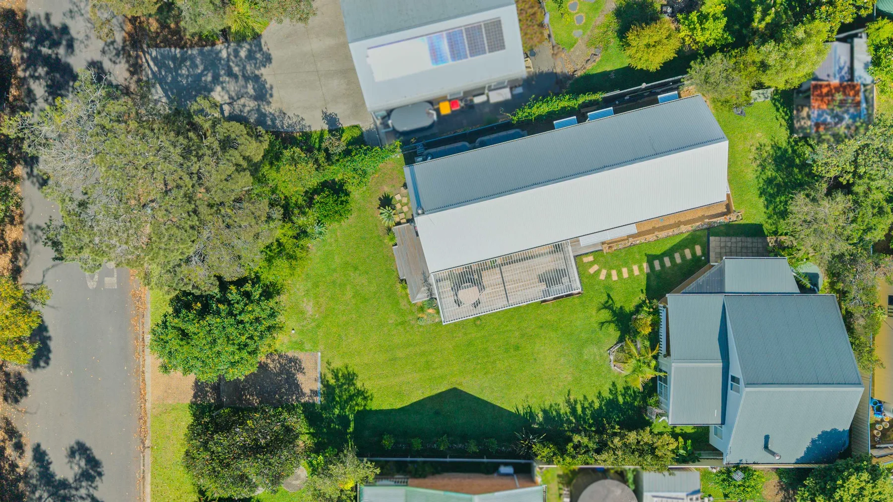 An aerial view shows several buildings around a broad green lawn.