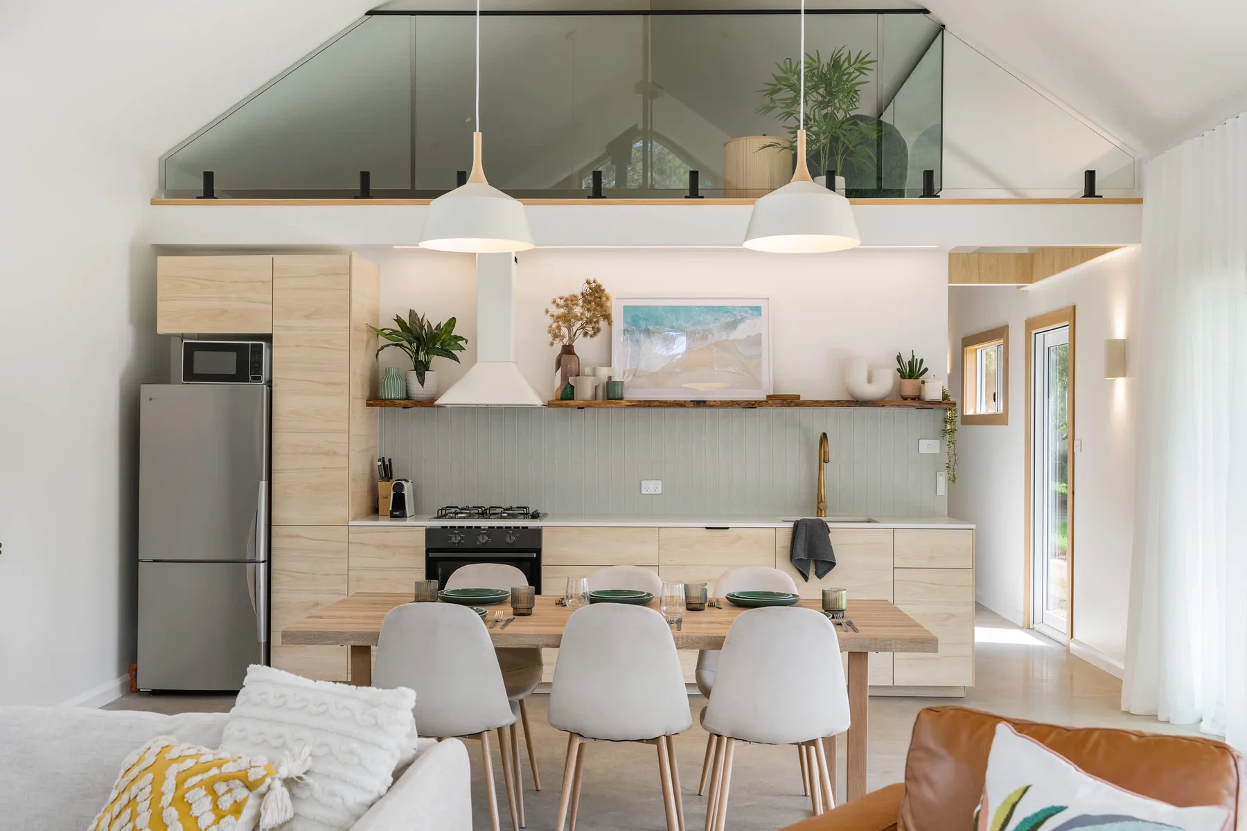 A bright open-plan kitchen and dining area with a counter, table, and seating.