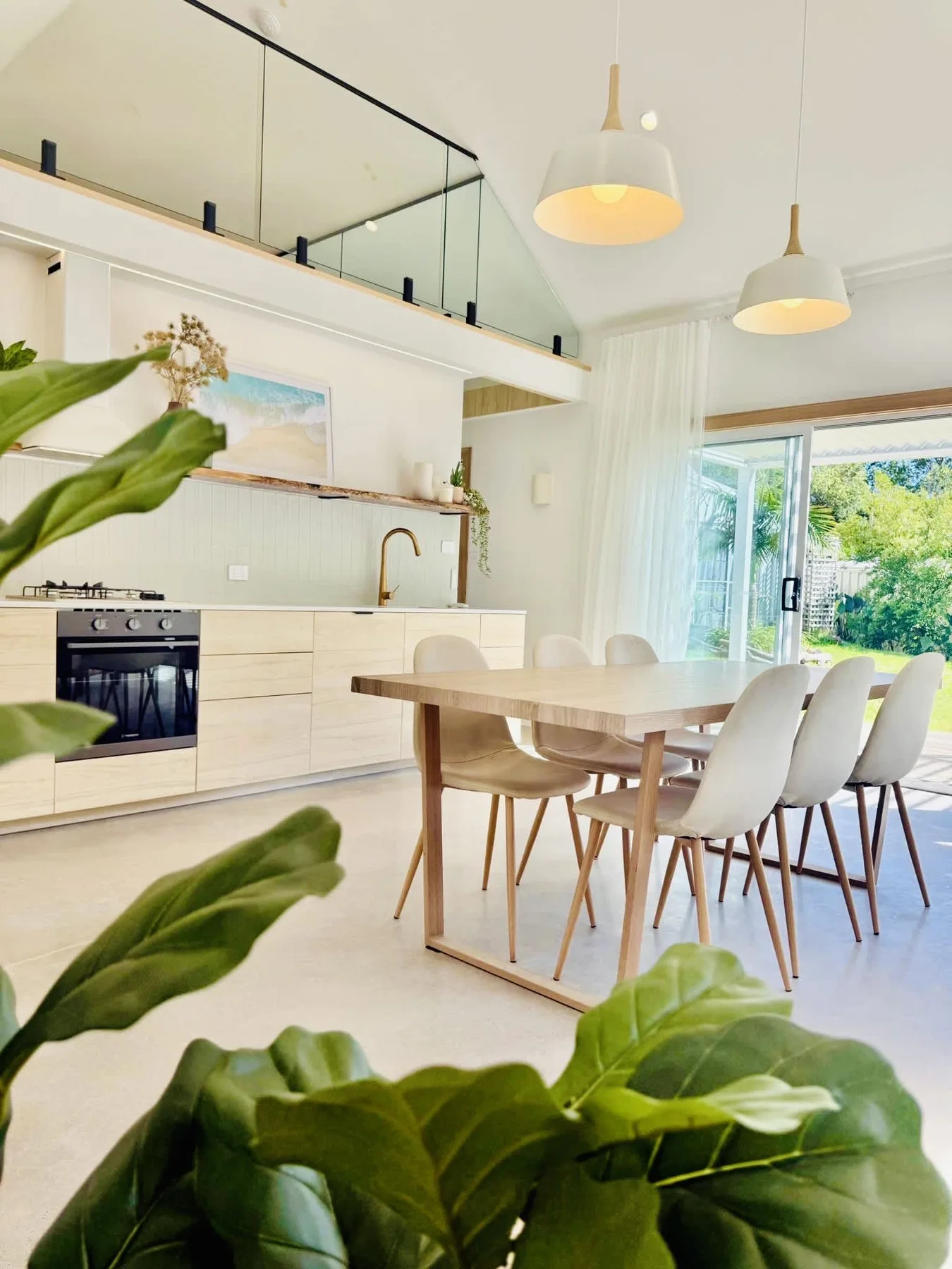 A bright kitchen and dining area with a table beside glass doors.