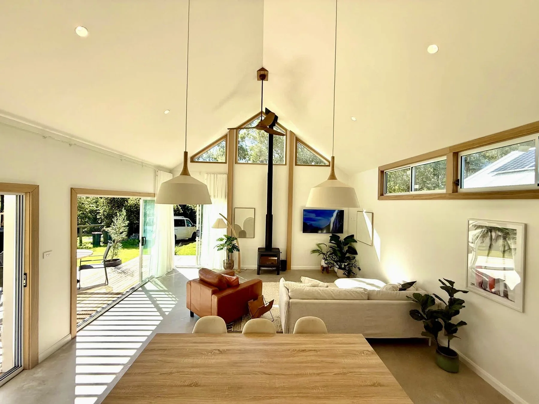 Bright living and dining area with large windows and seating.