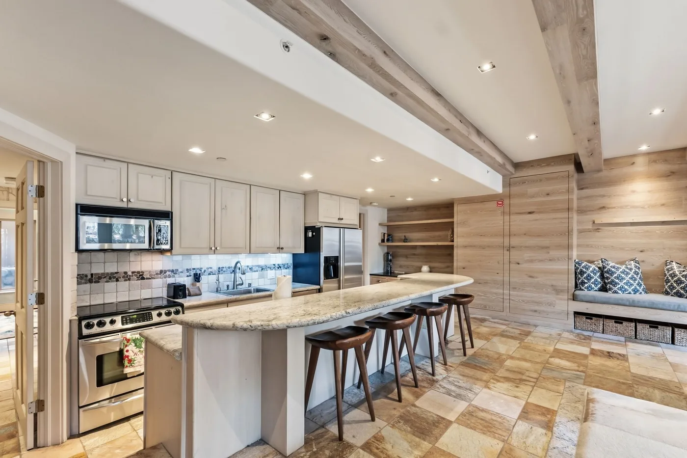 Una amplia cocina y comedor con una isla larga y asientos incorporados.