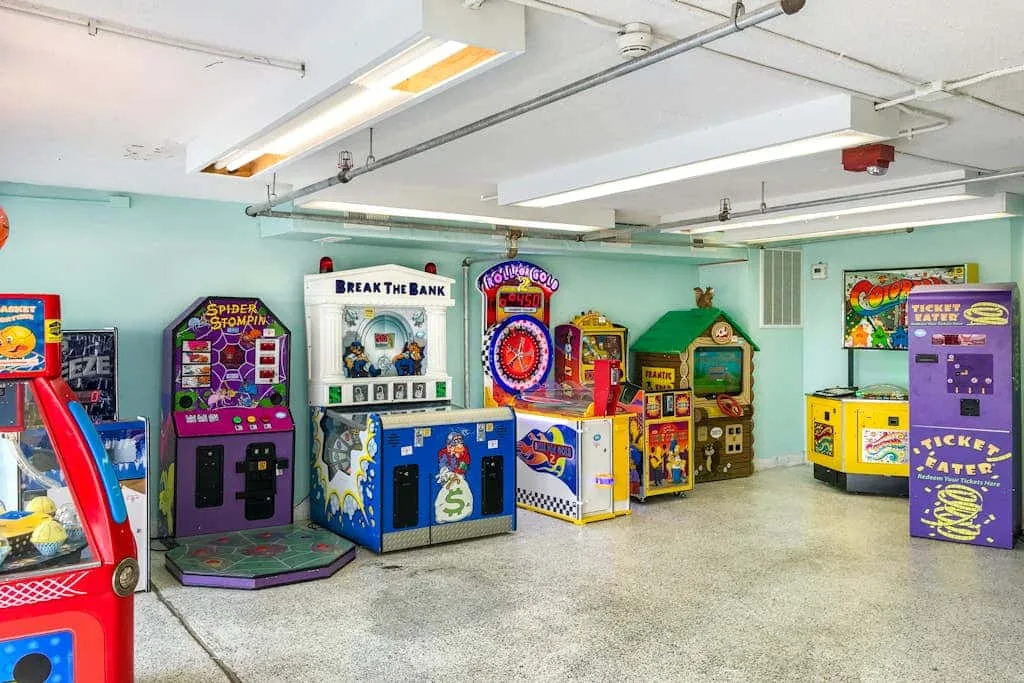 An indoor arcade room with colorful game machines arranged along the walls.