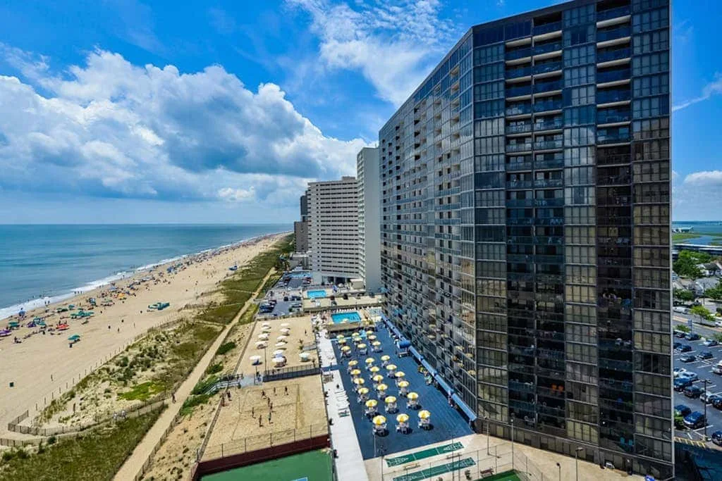 Aerial view of beachfront high-rise buildings beside a sandy shore and the ocean.