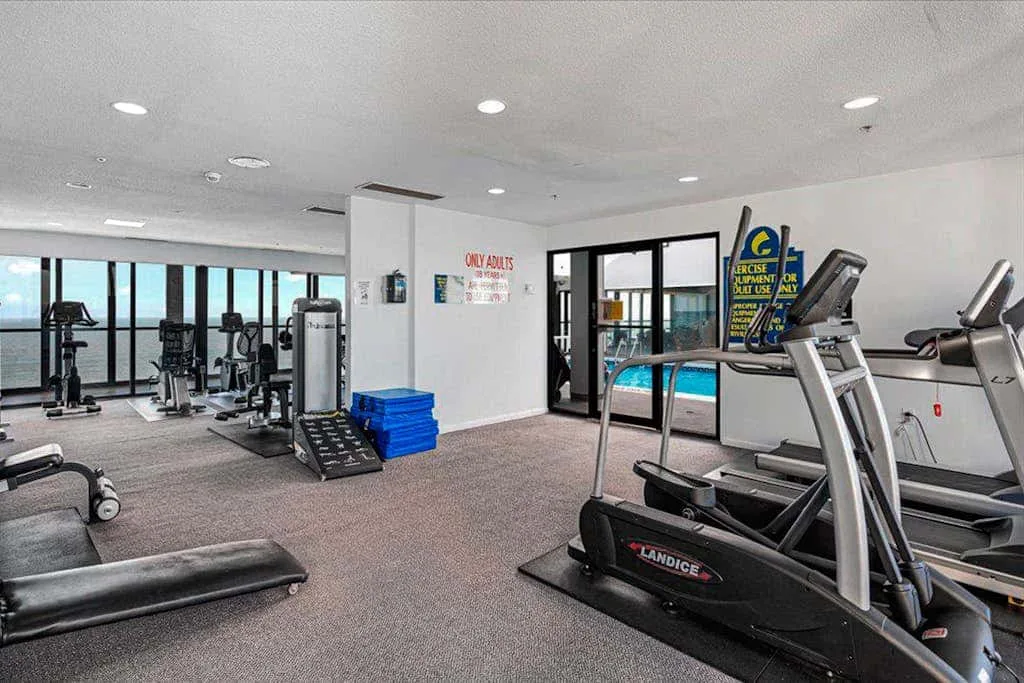 A fitness room with exercise machines and treadmills.