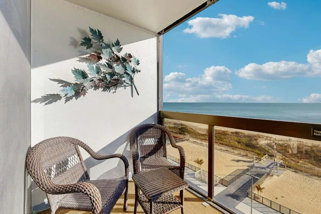 A balcony seating area overlooks the beach and ocean.