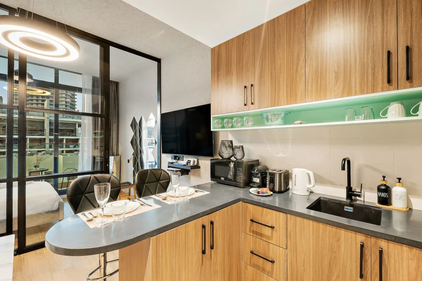 Una cocina moderna con una barra curva, gabinetes de madera y ventanales.