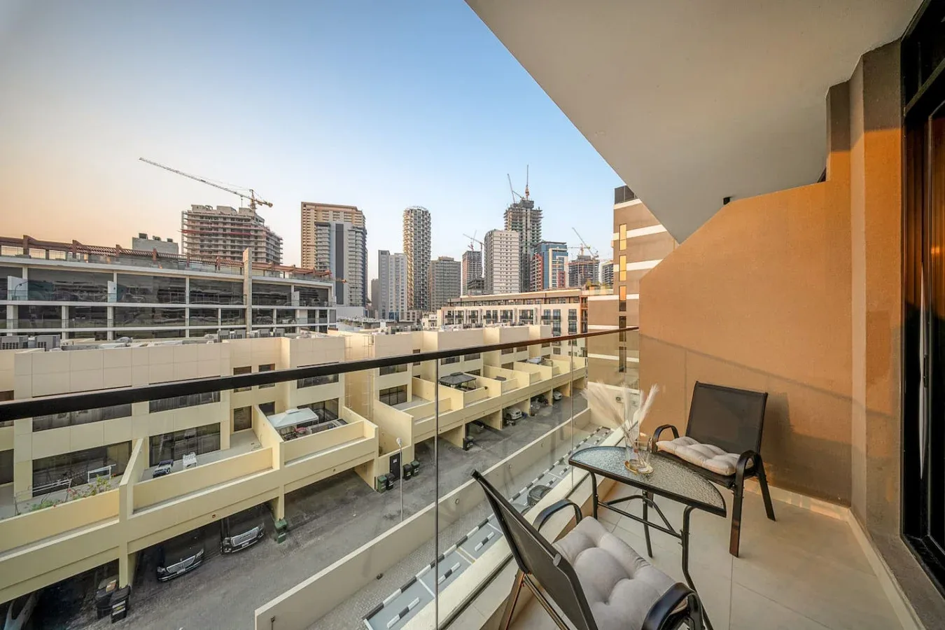 Una zona de estar en el balcón da a edificios cercanos y al horizonte urbano.