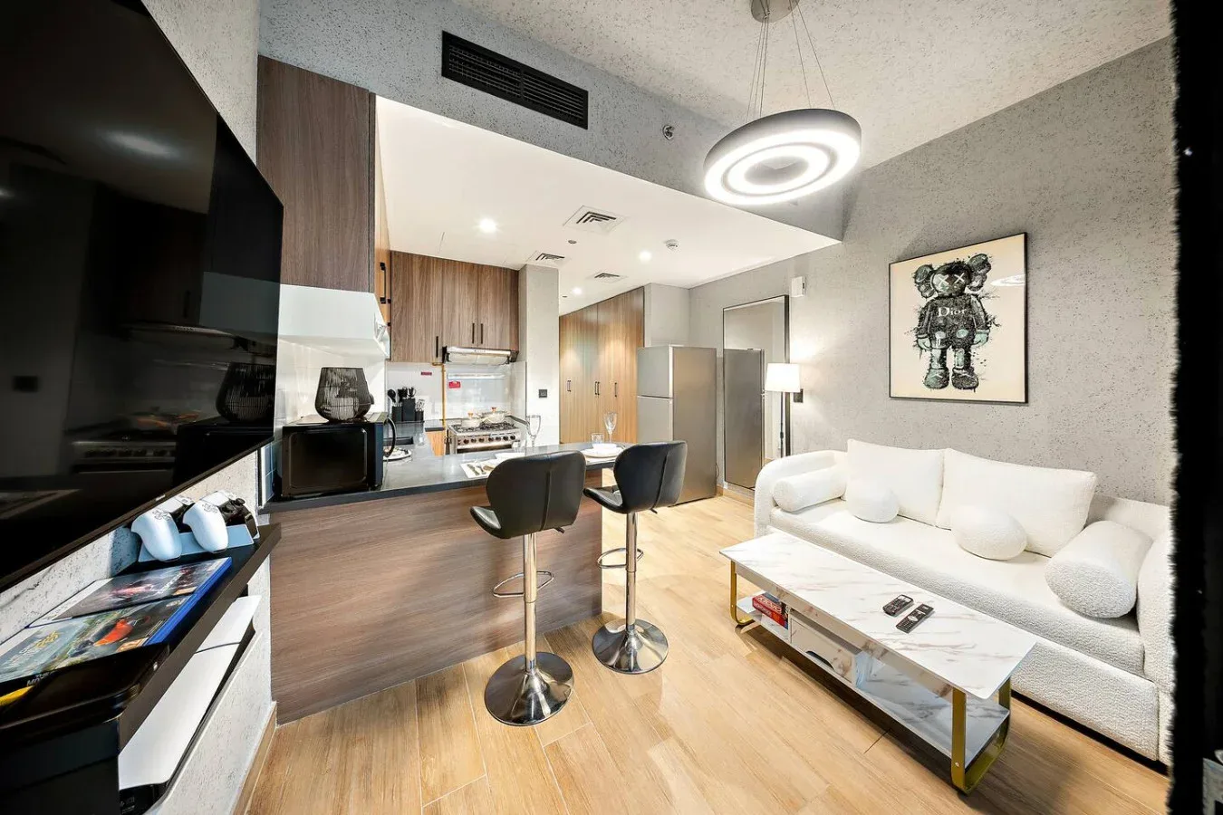 Una sala de estar de concepto abierto con barra de cocina, asientos y un sofá blanco.