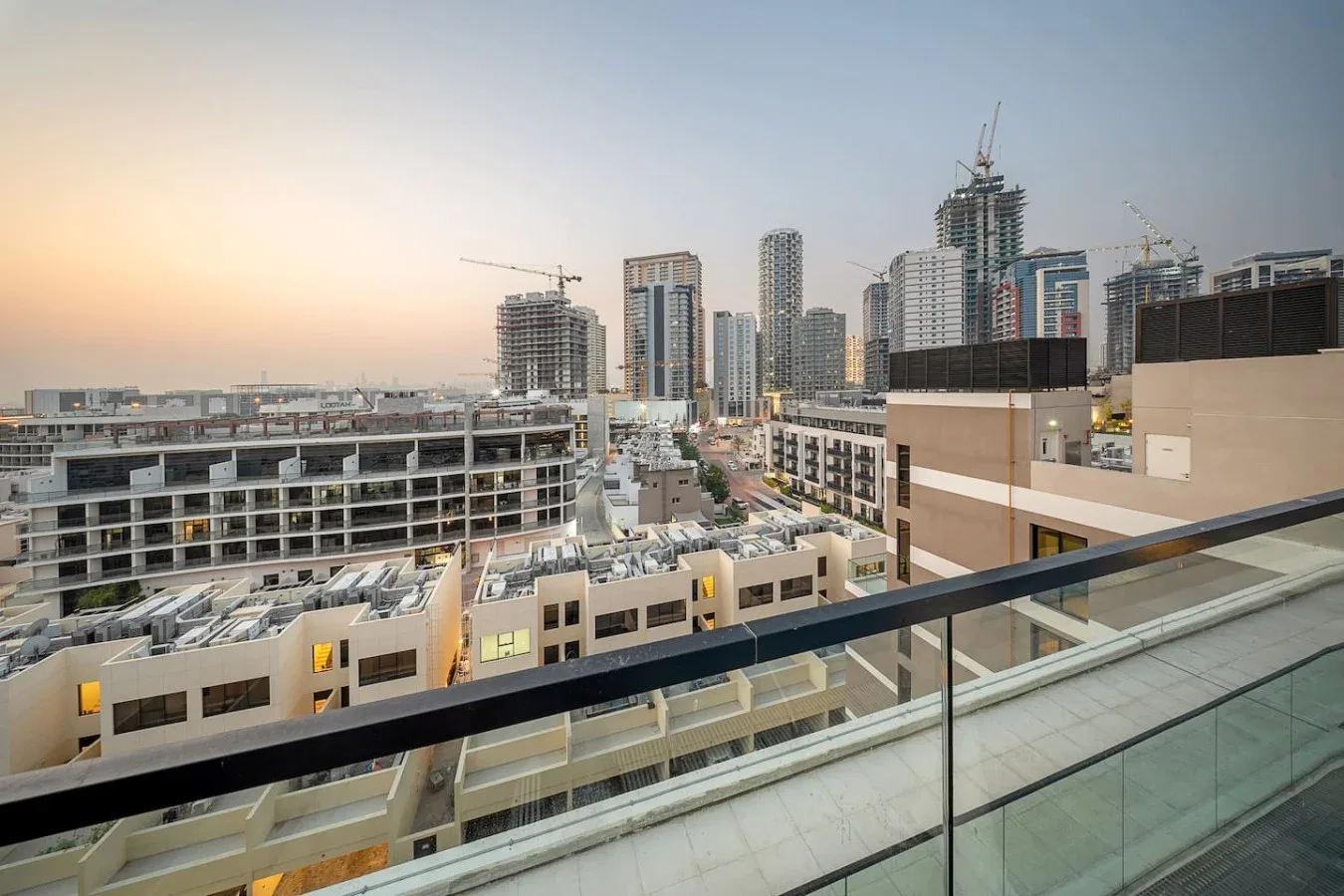 Un horizonte urbano con edificios altos en construcción al atardecer.