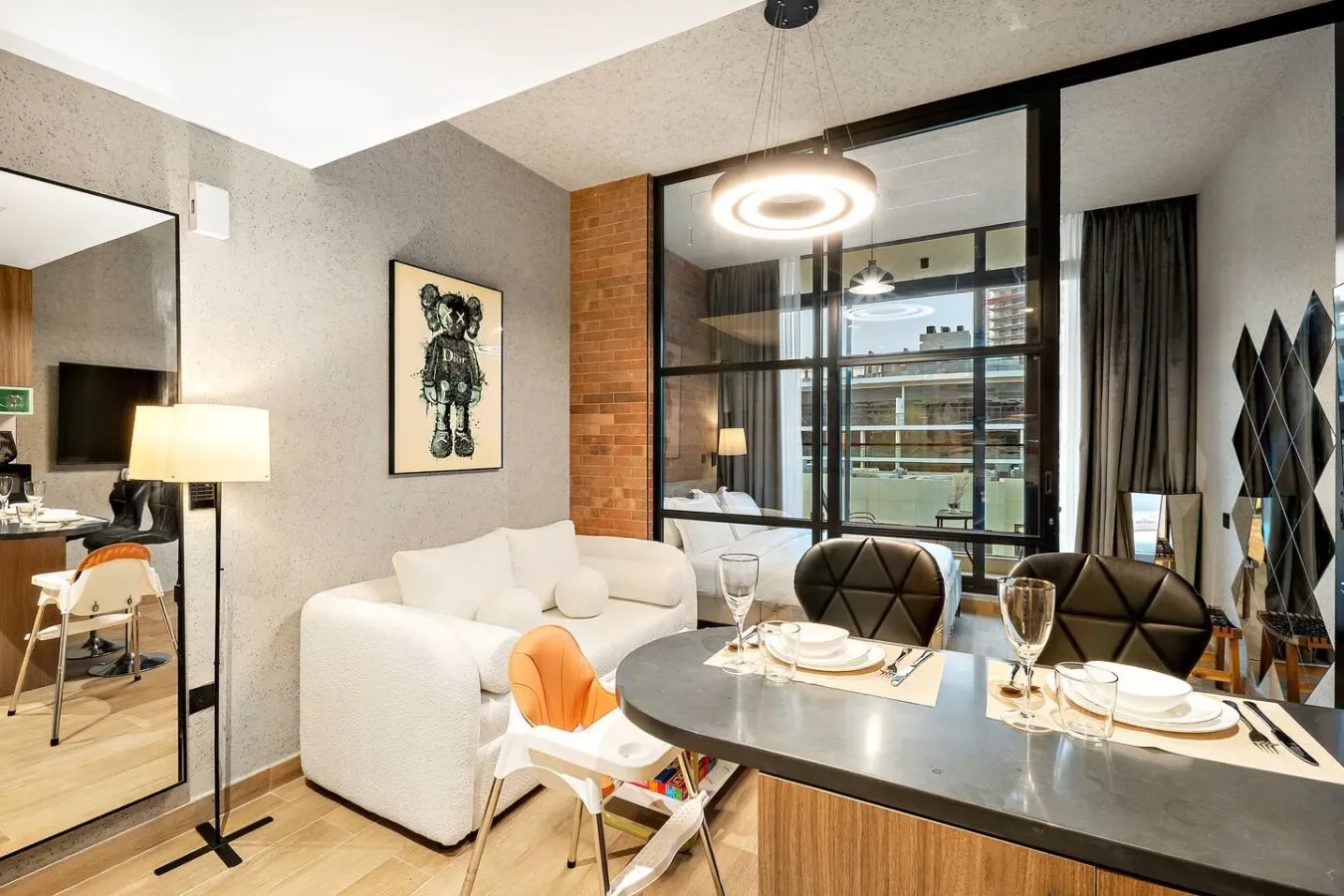 Una zona moderna de comedor y estar, con una mesa junto a asientos blancos.