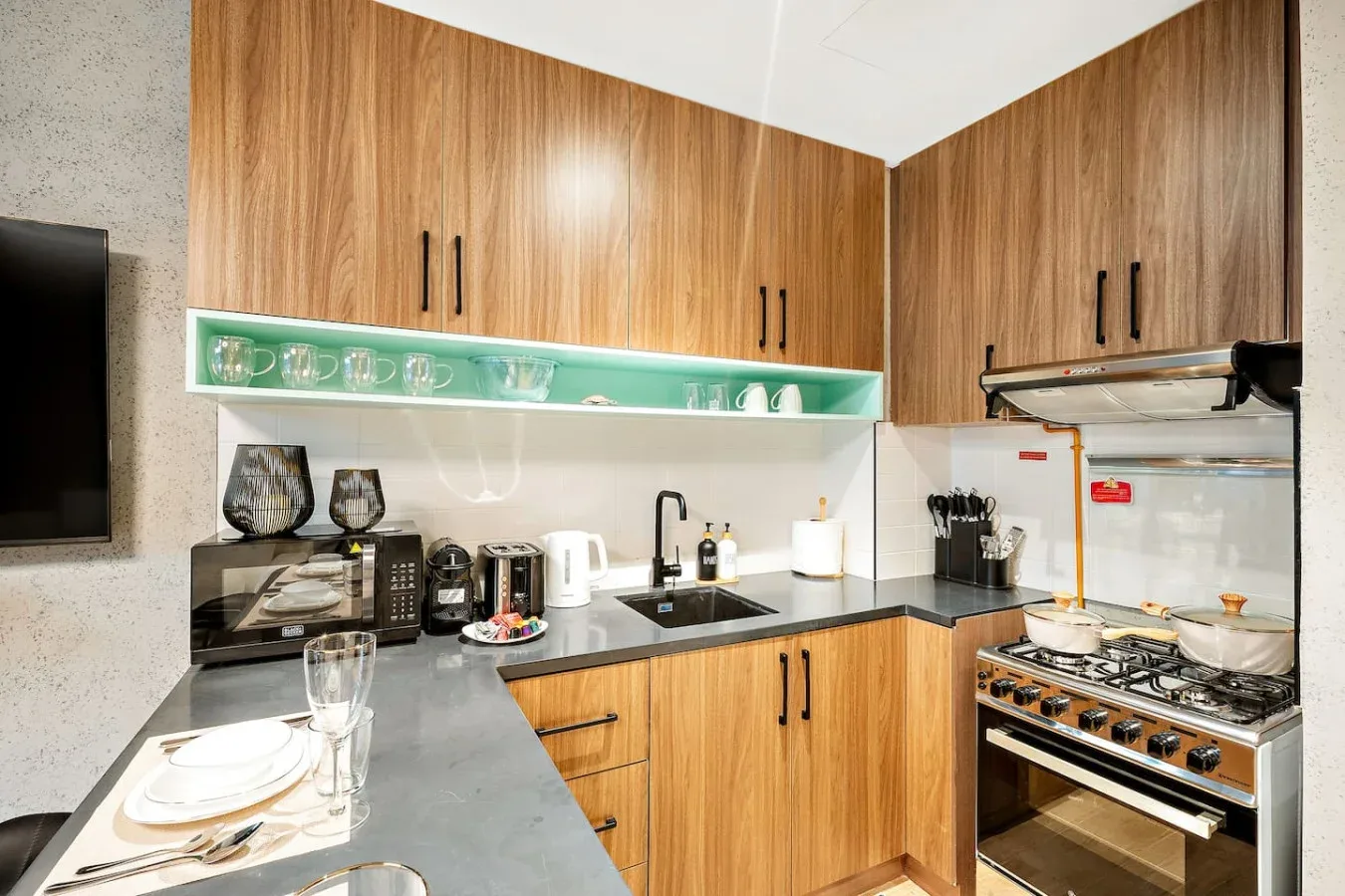 Una cocina moderna con gabinetes de madera, una encimera y electrodomésticos.