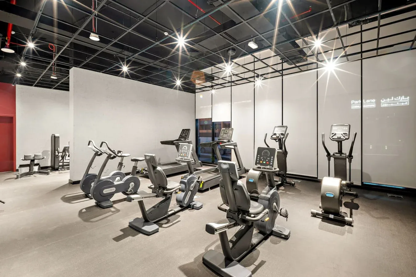 Un gimnasio con bicicletas estáticas y otras máquinas de ejercicio distribuidas por el suelo.