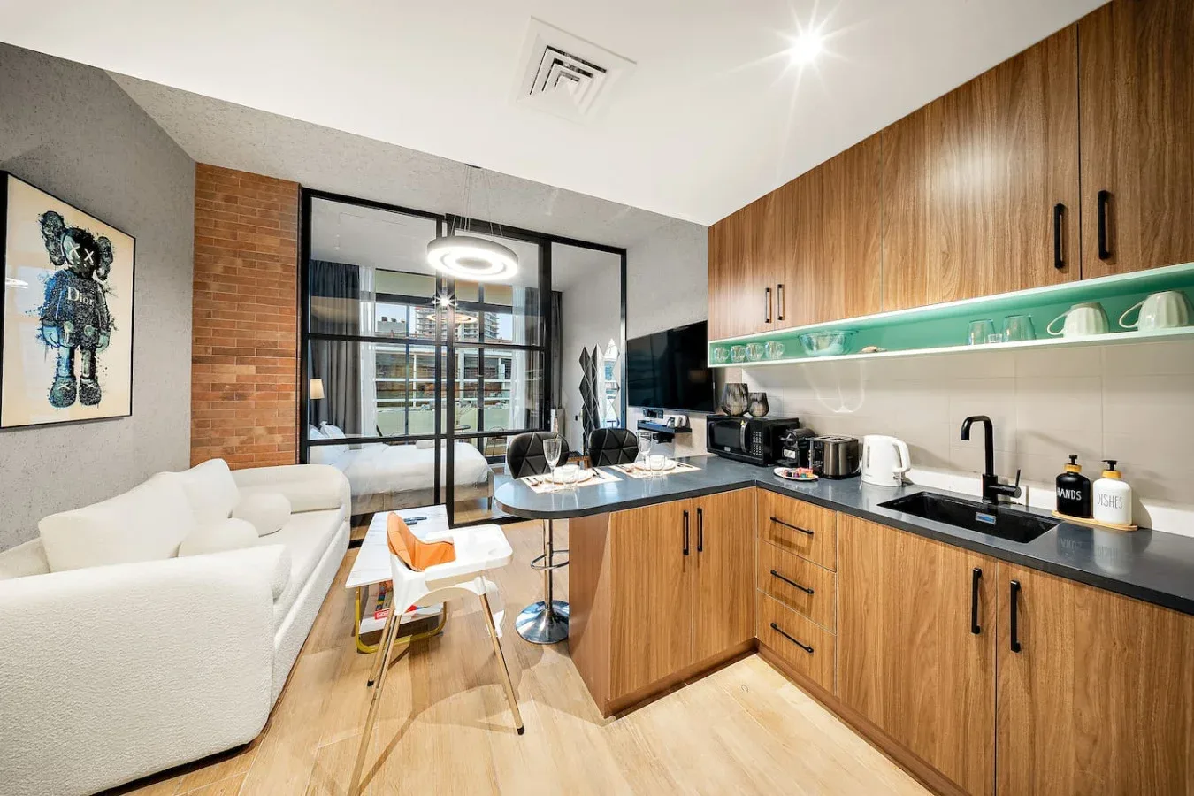 Cocina y sala de estar de planta abierta con una barra y asientos blancos.