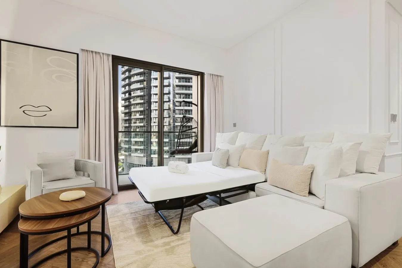 Una sala luminosa con asientos blancos y una gran ventana con vistas a edificios cercanos.