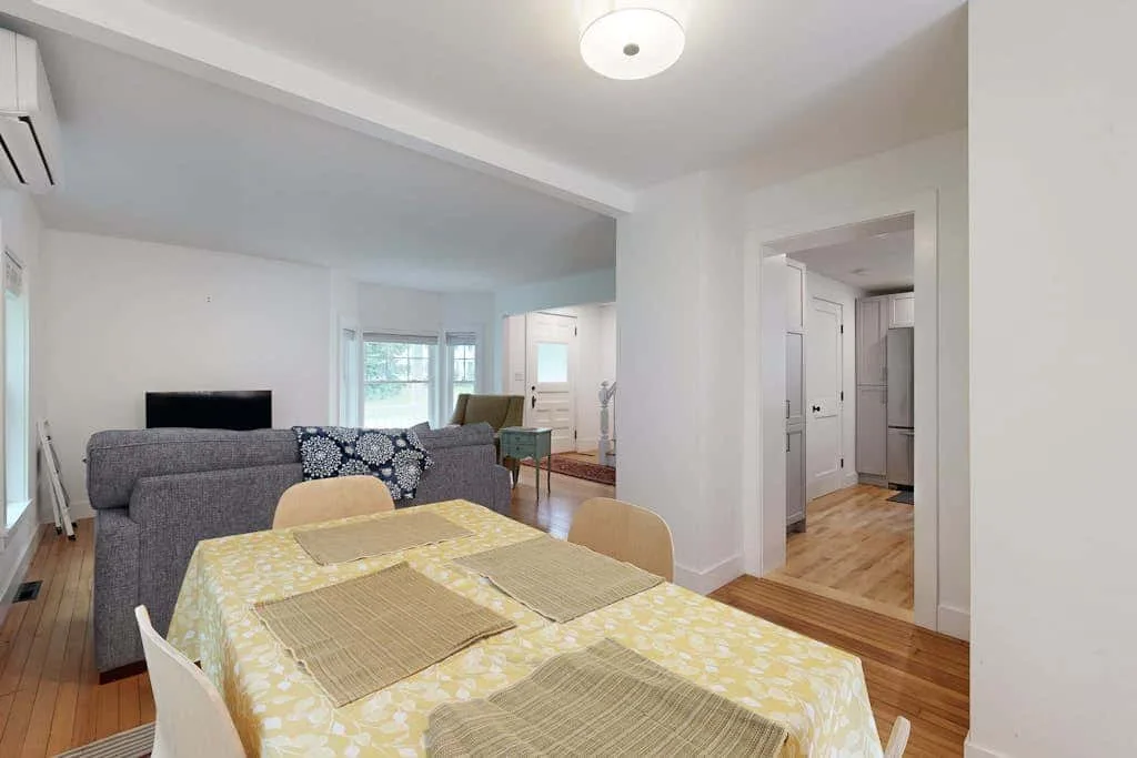 A dining area opens onto a living room, with a table and seating.