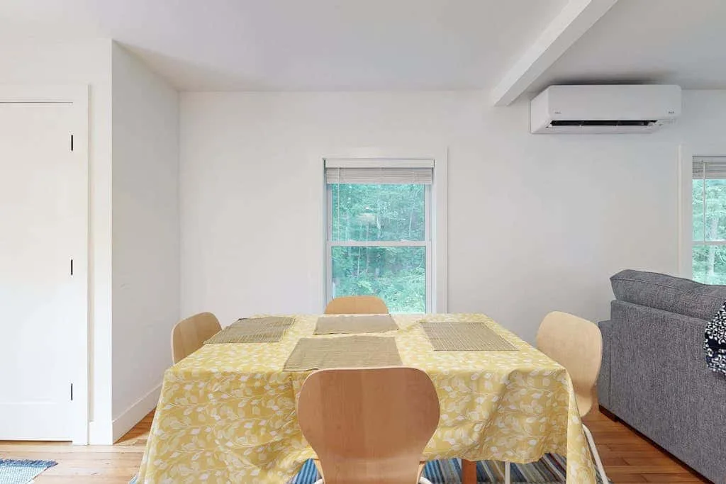 A dining area with a table covered in a yellow patterned tablecloth.