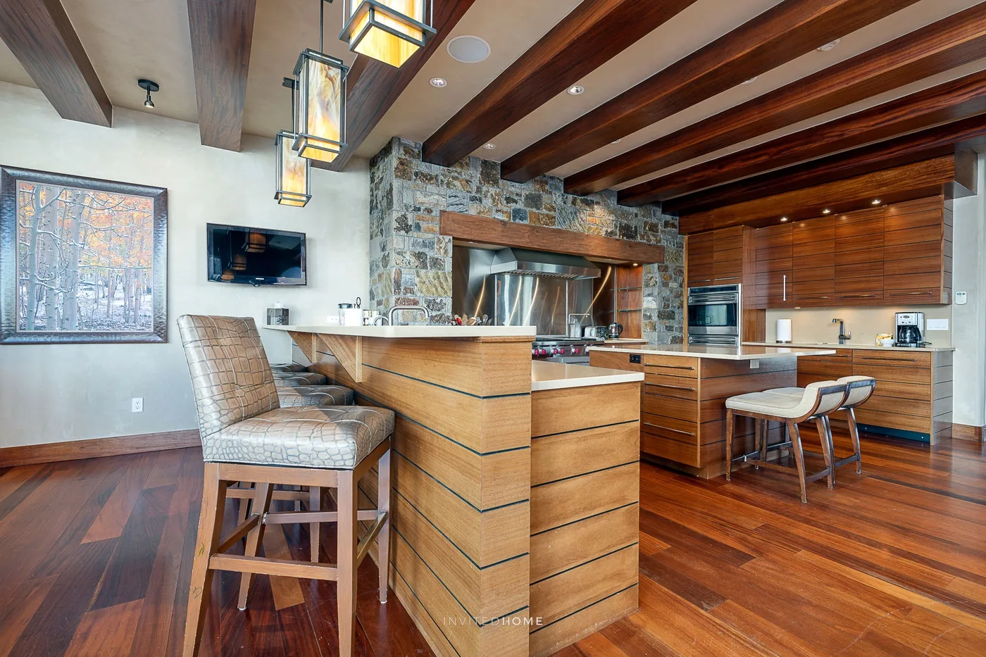 Una cocina revestida de madera con una isla central y asientos de barra.