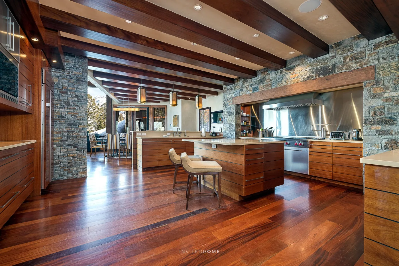 Una cocina amplia con una isla de madera y vigas expuestas en el techo.