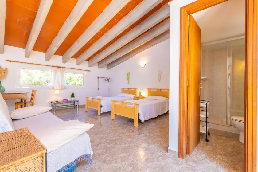 A bedroom with two beds and an open doorway to a bathroom.