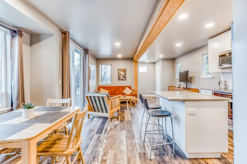 Sala de estar y comedor de concepto abierto con barra de cocina y mesa de comedor.