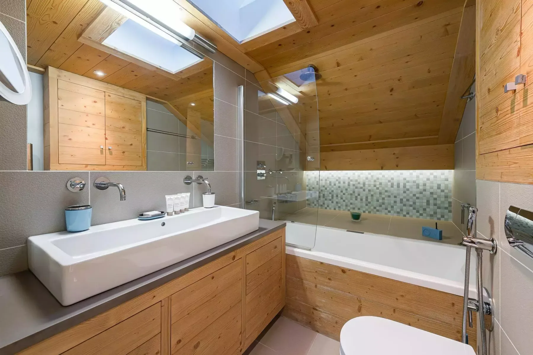 Un baño con bañera, lavabo y superficies revestidas de madera.