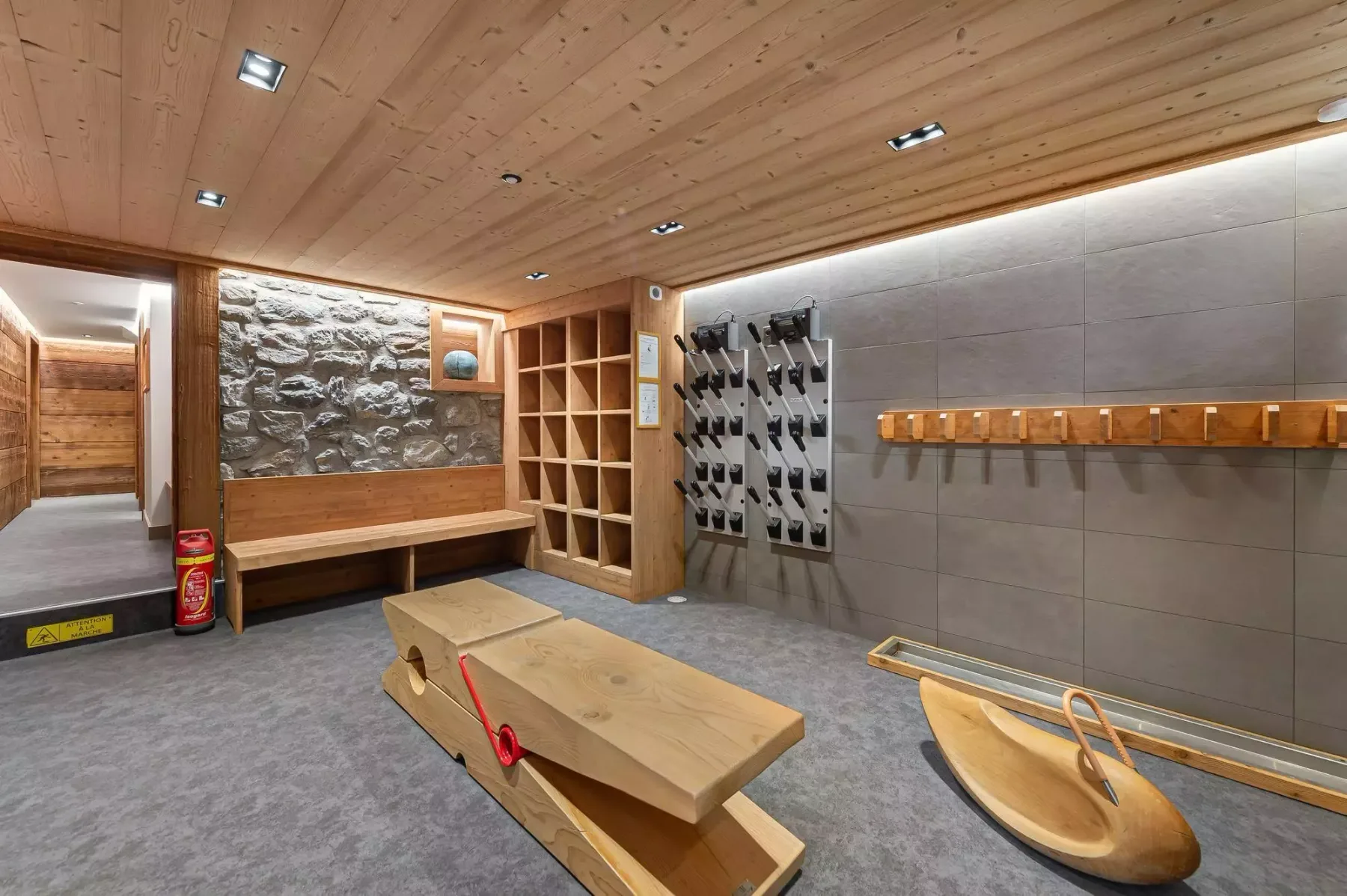 Una sala revestida de madera con un banco largo y filas de botellas de vino.