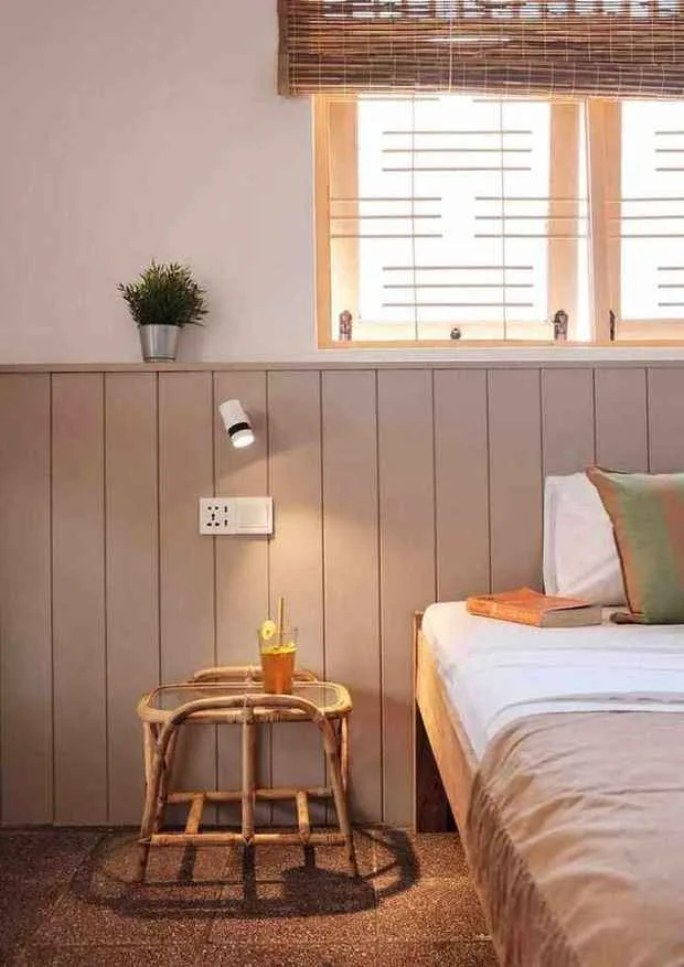Detalle junto a la cama con mesa de ratán
