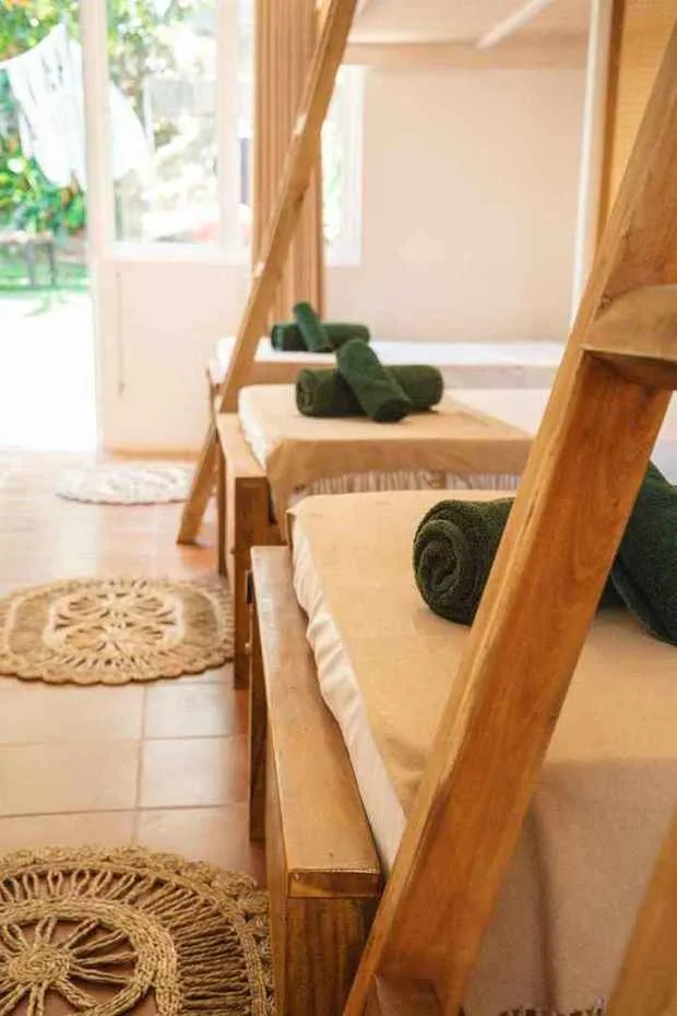 Camas hechas en dormitorio compartido, con toallas