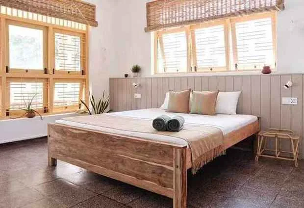 Habitación con cama king de teca y contraventanas amarillas