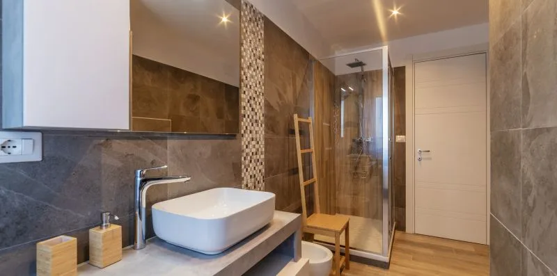 Un baño con un lavabo sobre encimera junto a una ducha de vidrio.
