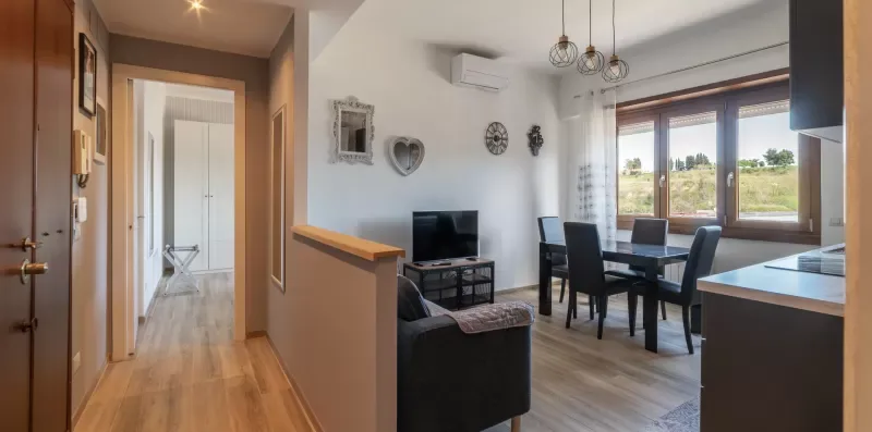 Una luminosa sala de estar y comedor de espacio abierto con grandes ventanas.