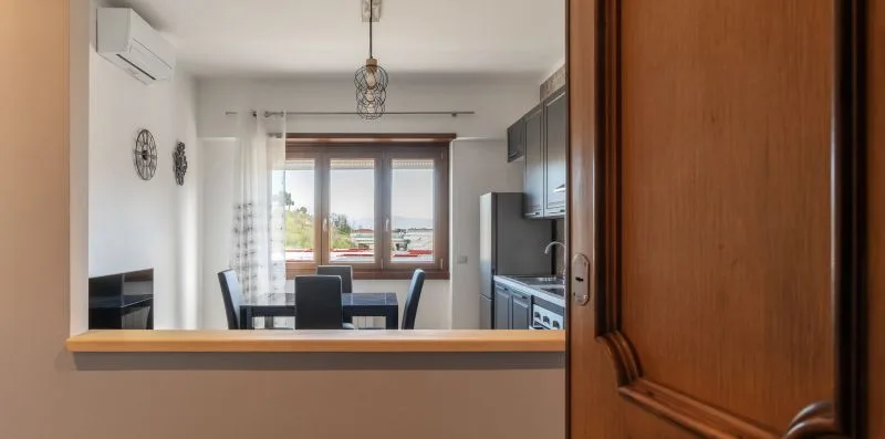 Cocina y comedor con una mesa junto a la ventana.