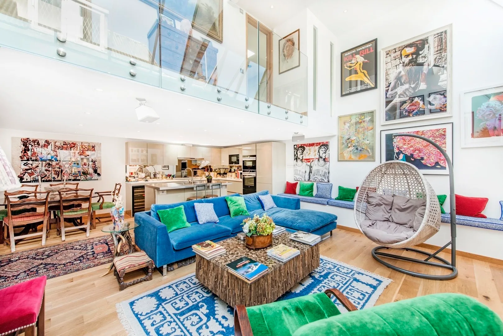 A bright living room with colorful seating and framed artwork on the walls.
