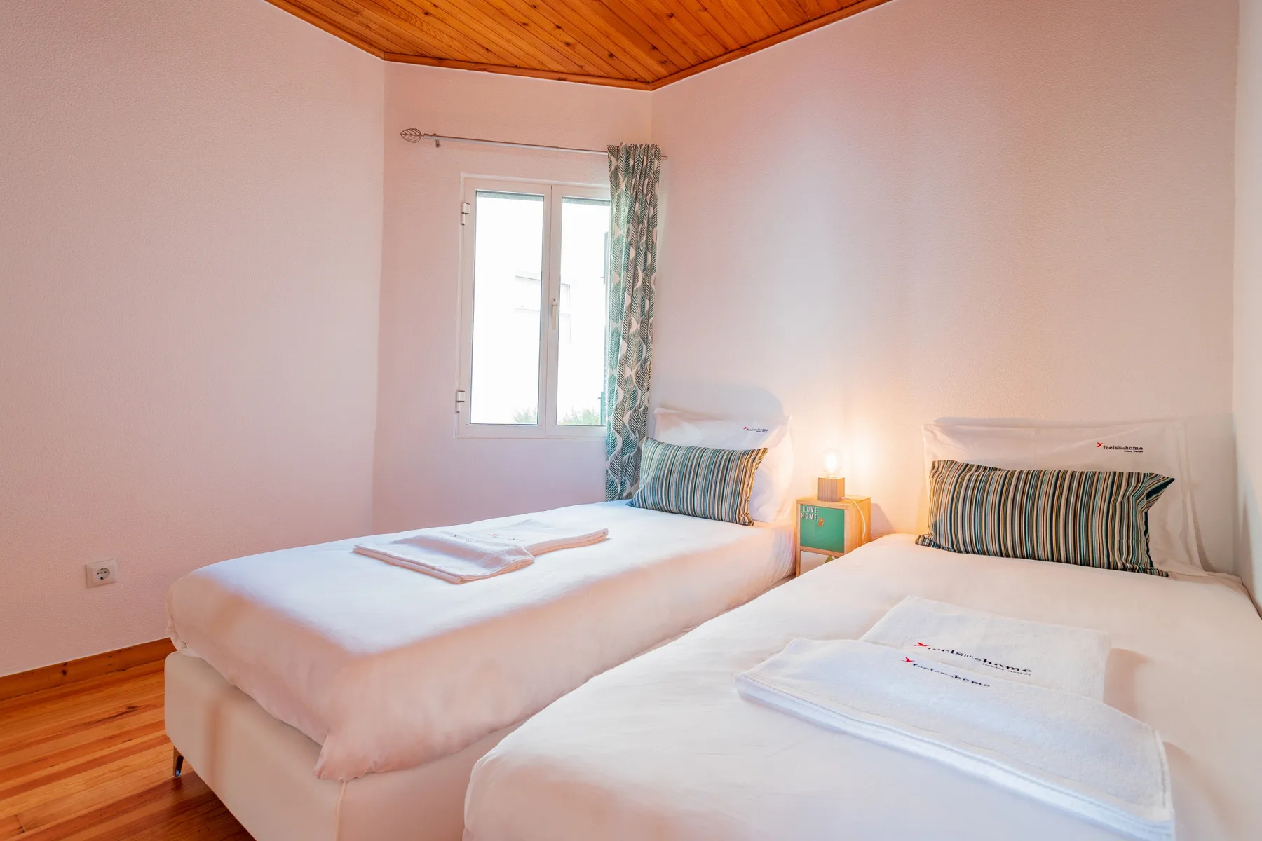 A twin bedroom with two single beds and a window.