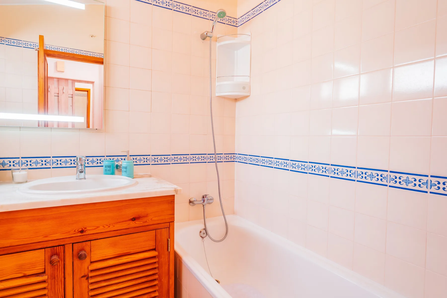 A tiled bathroom with a sink and bathtub.