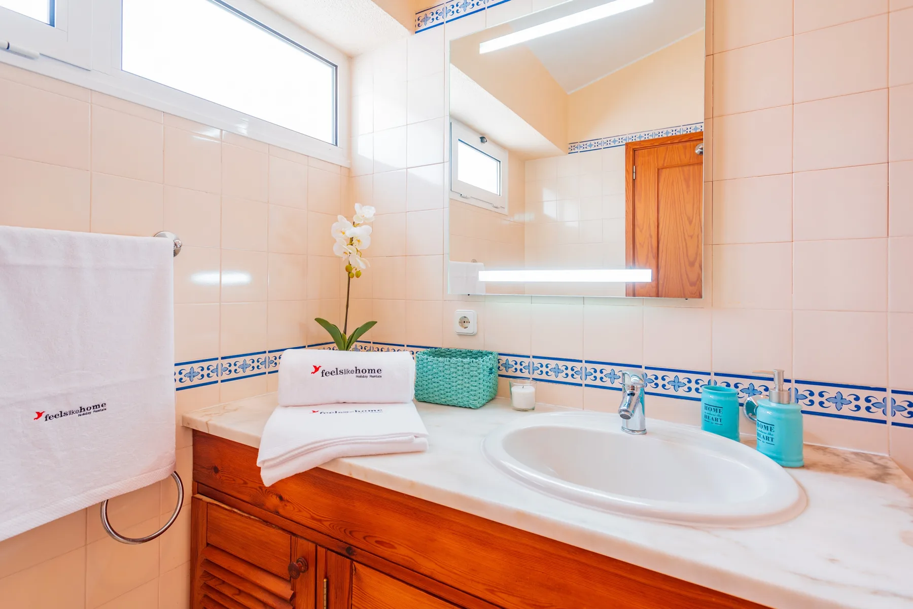 A tiled bathroom with a large mirror above the sink.