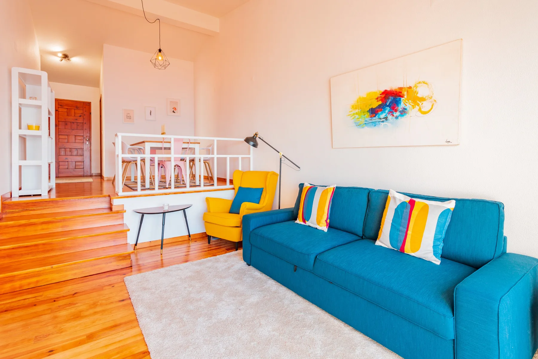 A living room with a blue sofa and colorful cushions.