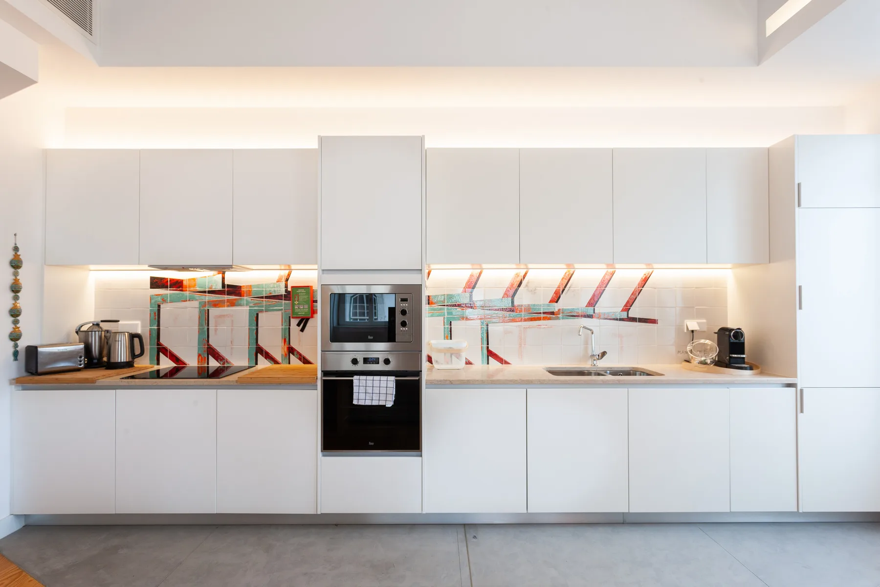 Una cocina moderna con gabinetes blancos y un horno integrado.