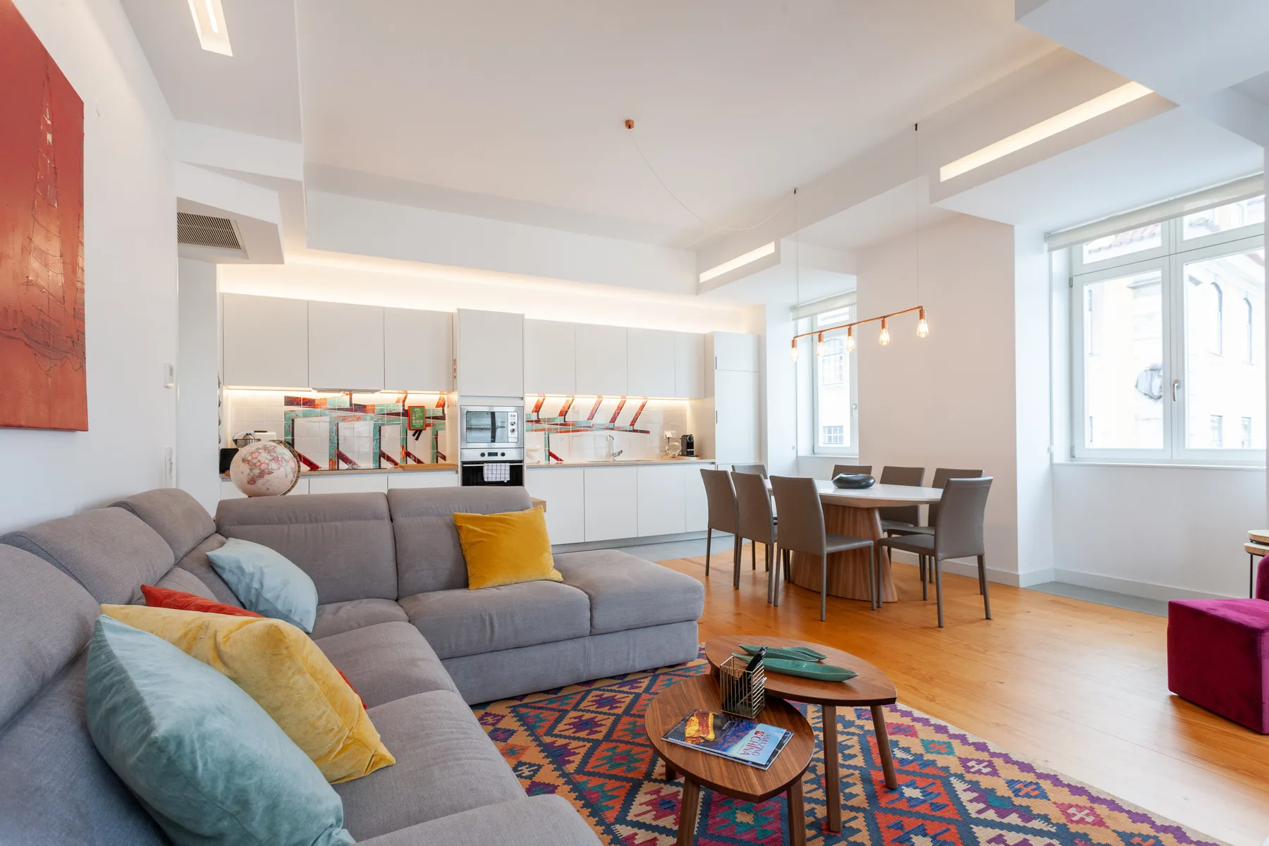 An open-plan living and dining area with a kitchen and large windows.