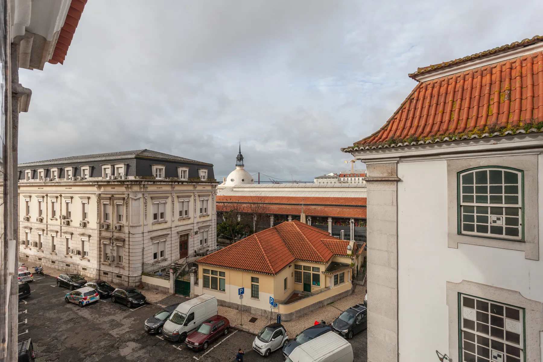 Una calle urbana con edificios históricos y tejados de tejas rojas.