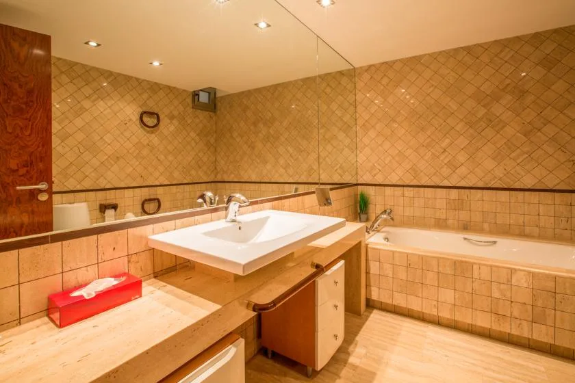 Un baño con azulejos, lavabo y bañera.