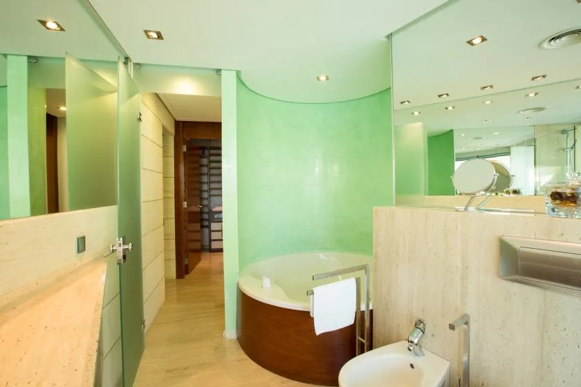 Un baño con una bañera redonda y un lavabo separado.