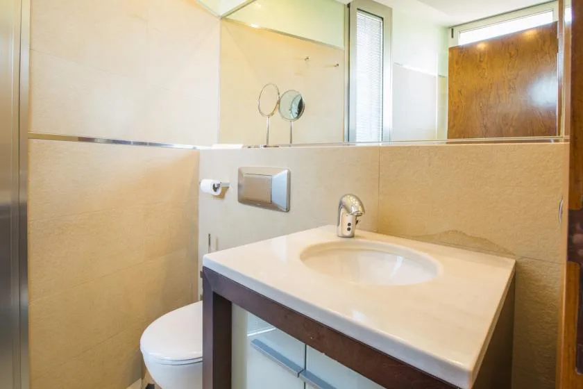 Un lavabo de baño con un fregadero ovalado y un inodoro al lado.