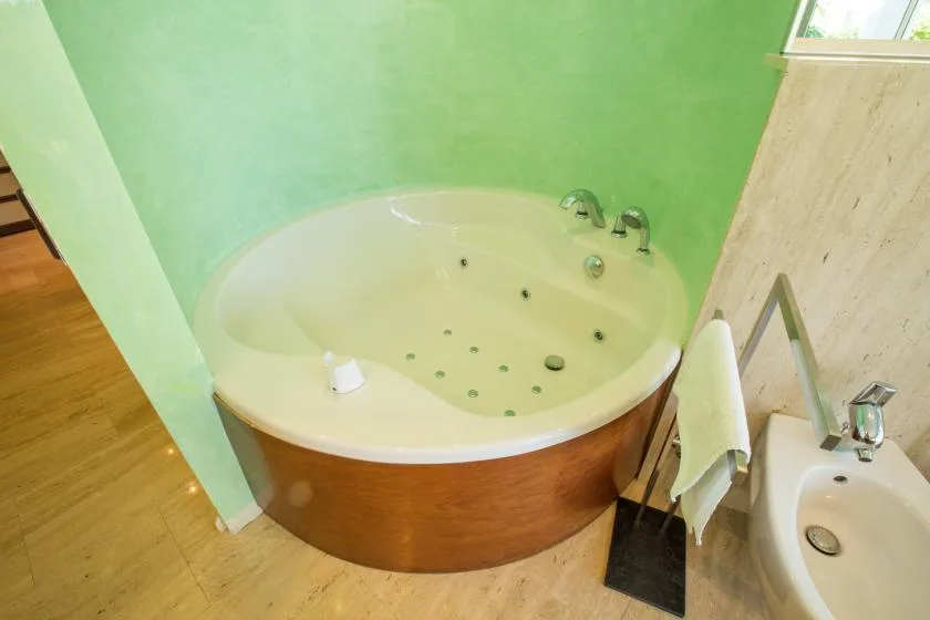 Un baño con una bañera redonda junto a un lavabo.